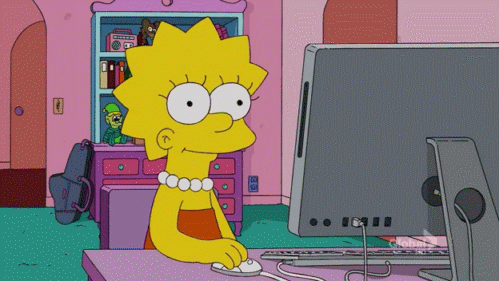 Lisa Simpson sits at a Mac computer at her bedroom desk